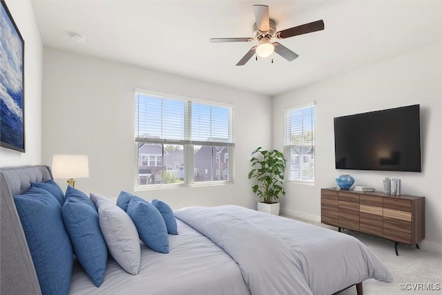 bedroom with ceiling fan, baseboards, and light carpet