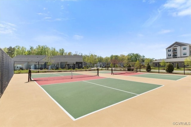 view of tennis court with community basketball court and fence