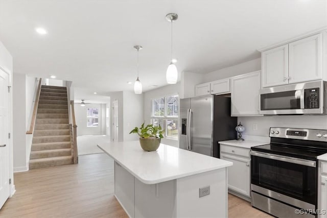 kitchen featuring light countertops, a kitchen island, white cabinetry, and appliances with stainless steel finishes