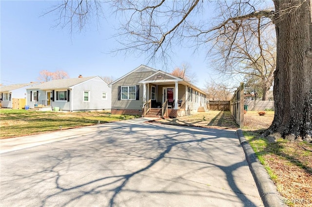 bungalow-style house featuring covered porch and fence