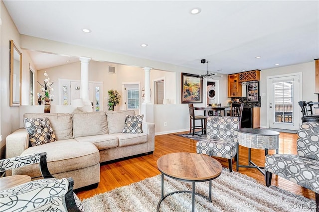 living area with recessed lighting, visible vents, light wood-style floors, decorative columns, and ceiling fan