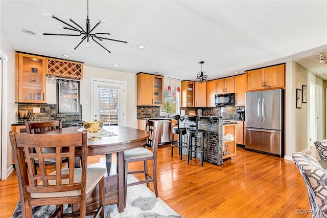 dining space featuring an inviting chandelier, light wood finished floors, and recessed lighting