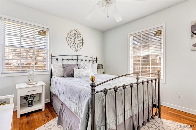 bedroom with baseboards, a ceiling fan, and wood finished floors