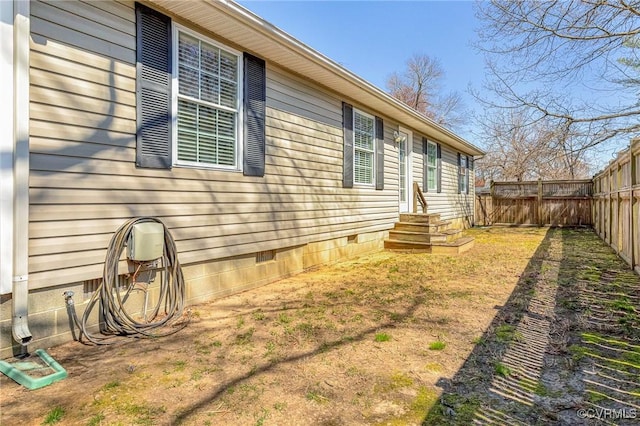 view of side of property featuring crawl space and a fenced backyard
