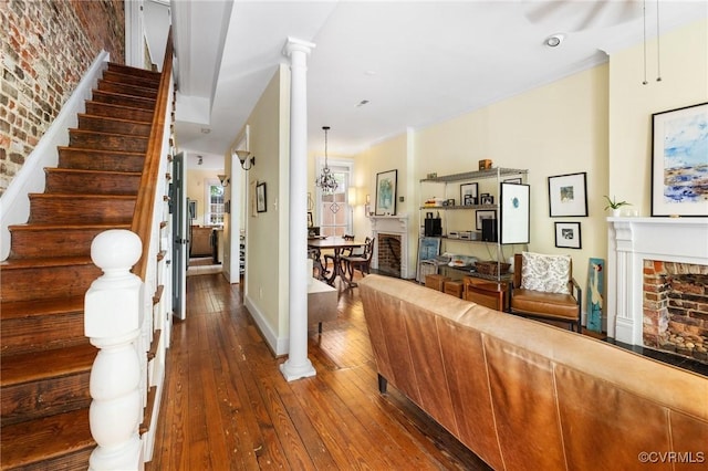 116 N 29th St, Richmond, VA 23223 - living room featuring brick wall, hardwood / wood-style floors, a brick fireplace, baseboards, and stairway