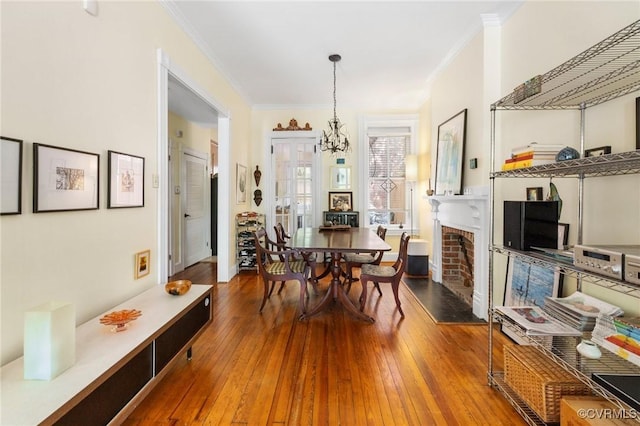 116 N 29th St, Richmond, VA 23223 - dining area featuring a notable chandelier, hardwood / wood-style floors, ornamental molding, and a brick fireplace