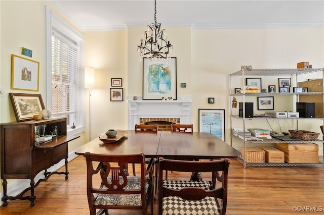 116 N 29th St, Richmond, VA 23223 - dining space with ornamental molding, an inviting chandelier, hardwood / wood-style floors, and a brick fireplace