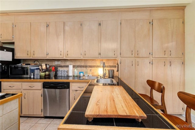 116 N 29th St, Richmond, VA 23223 - kitchen with a sink, appliances with stainless steel finishes, light brown cabinetry, light tile patterned flooring, and backsplash