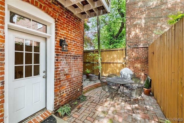 116 N 29th St, Richmond, VA 23223 - doorway to property with fence, a patio area, and brick siding