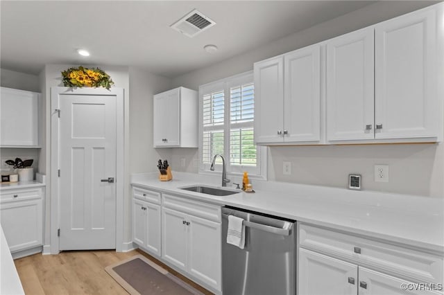 8106 W Danube Loop, New Kent, VA 23124 - kitchen with stainless steel dishwasher, a sink, white cabinets, light wood finished floors, and light countertops