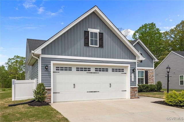 8106 W Danube Loop, New Kent, VA 23124 - view of front facade featuring board and batten siding, stone siding, concrete driveway, a garage, and fence