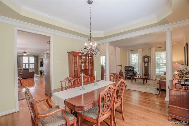 dining space with light wood-type flooring, decorative columns, and crown molding