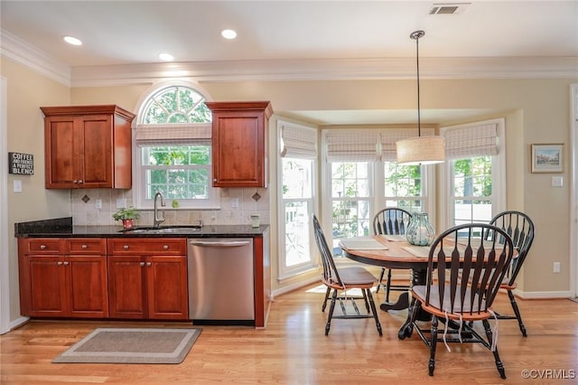 kitchen featuring stainless steel dishwasher, crown molding, visible vents, a sink, and backsplash