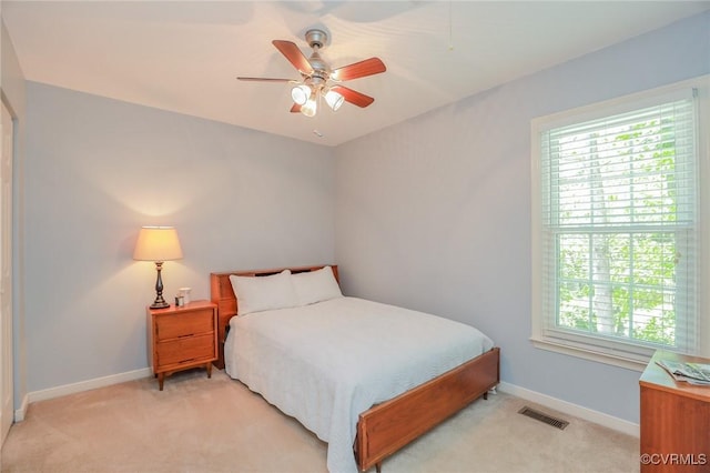 bedroom featuring baseboards, visible vents, light carpet, and ceiling fan