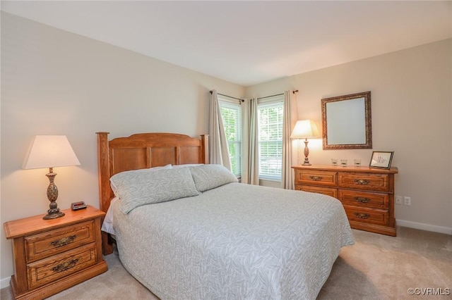 bedroom with baseboards and light colored carpet