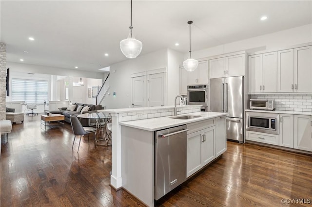 2611 Kensington Ave, Richmond, VA 23220 - kitchen with a sink, decorative backsplash, open floor plan, stainless steel appliances, and dark wood-style flooring