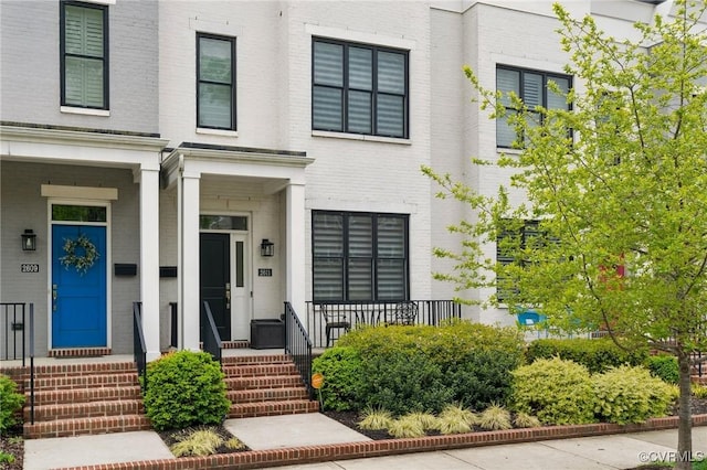 2611 Kensington Ave, Richmond, VA 23220 - view of front of home featuring covered porch, brick siding, and central AC unit