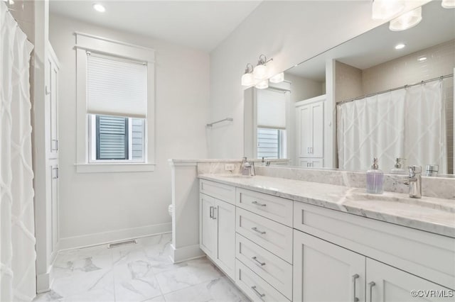 2611 Kensington Ave, Richmond, VA 23220 - bathroom featuring marble finish floor, double vanity, visible vents, a sink, and baseboards