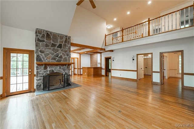 328 Perrow Ln, Manakin Sabot, VA 23103 - unfurnished living room featuring ceiling fan, a stone fireplace, wood finished floors, baseboards, and a high ceiling