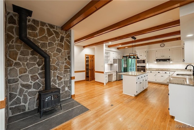328 Perrow Ln, Manakin Sabot, VA 23103 - kitchen with a wood stove, a sink, baseboards, stainless steel appliances, and white cabinetry