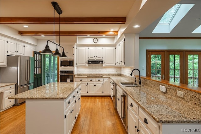 328 Perrow Ln, Manakin Sabot, VA 23103 - kitchen with a sink, light wood finished floors, stainless steel appliances, a peninsula, and a skylight