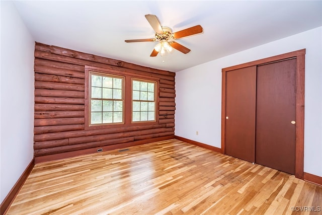 6631 Rural Point Rd, Mechanicsville, VA 23116 - unfurnished bedroom featuring log walls, baseboards, light wood-type flooring, a closet, and ceiling fan