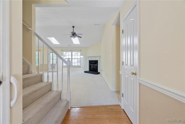 14530 Hancock Ridge Ct, Chesterfield, VA 23832 - stairway featuring ceiling fan, a tiled fireplace, wood finished floors, a skylight, and baseboards
