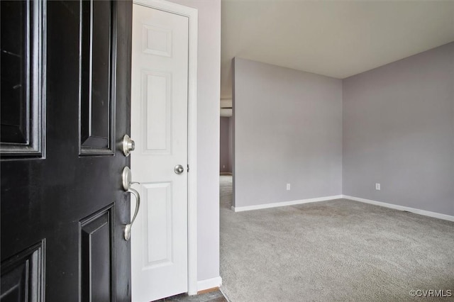 carpeted empty room featuring baseboards