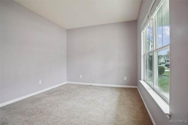 carpeted spare room featuring baseboards