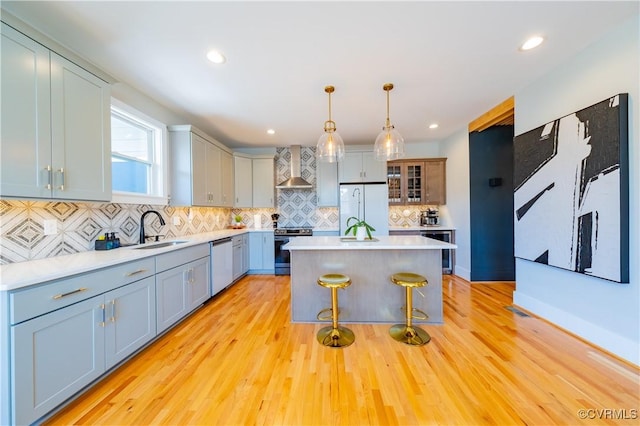 300 W 25th St, Richmond, VA 23225 - kitchen featuring wall chimney range hood, a kitchen breakfast bar, a sink, appliances with stainless steel finishes, and a kitchen island
