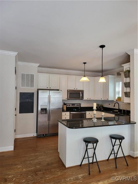 640 Coniston Manor Dr, Gordonsville, VA 22942 - kitchen with dark countertops, crown molding, a peninsula, appliances with stainless steel finishes, and visible vents