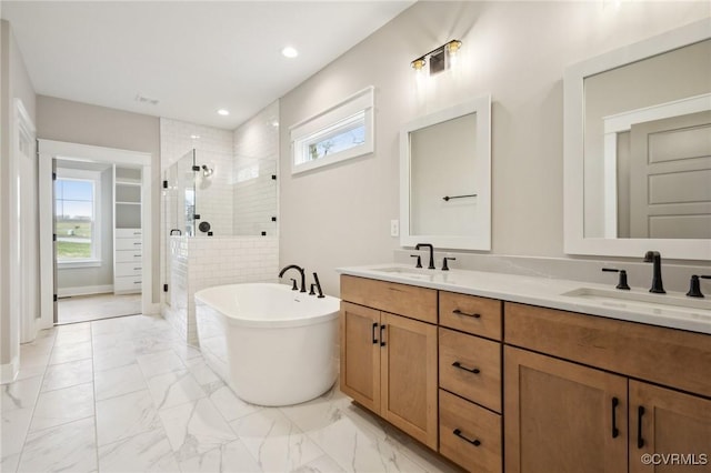 bathroom with marble finish floor, a sink, and a shower stall