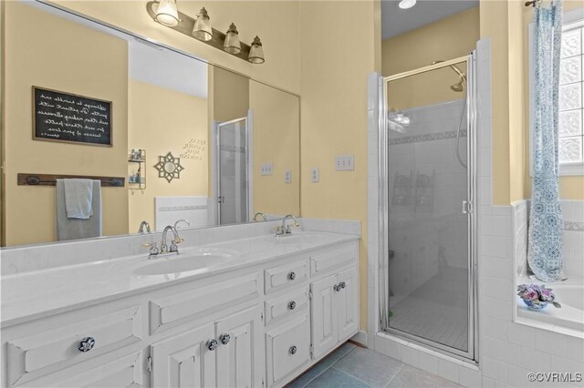 full bathroom with double vanity, a sink, a stall shower, and tile patterned floors