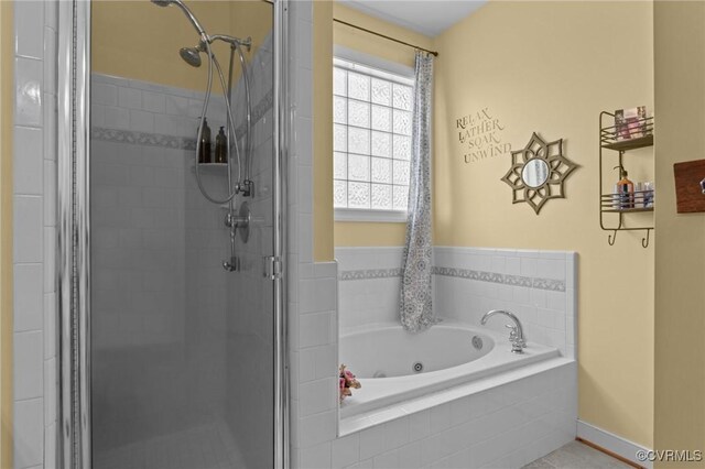bathroom featuring baseboards, a shower stall, and a bath