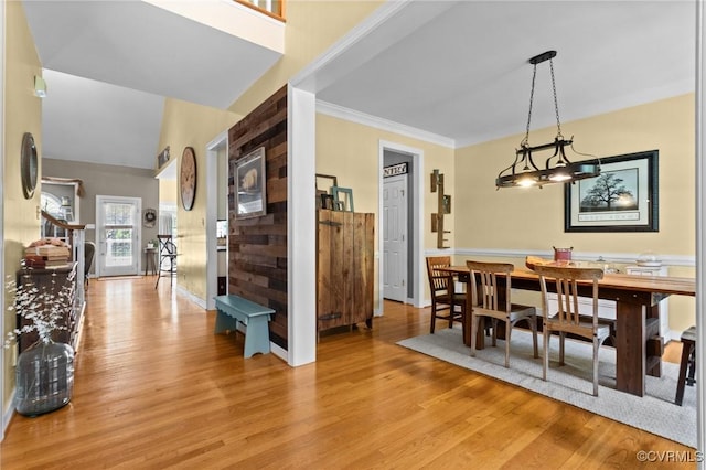 dining space with ornamental molding and light wood-style floors