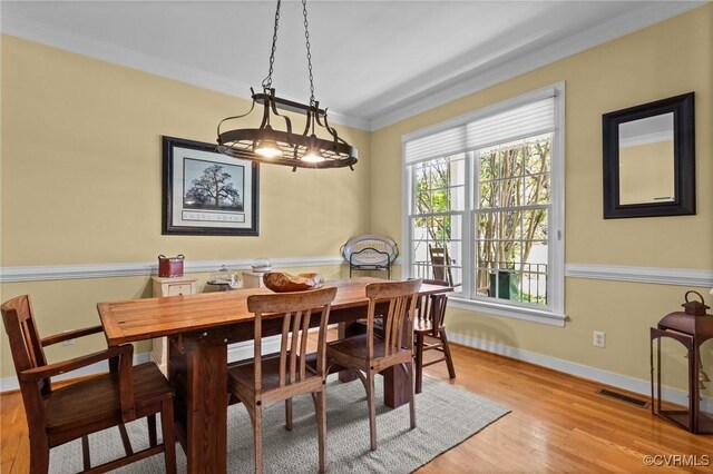 dining area with visible vents, ornamental molding, baseboards, and wood finished floors