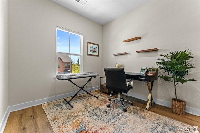 home office featuring wood finished floors, visible vents, and baseboards