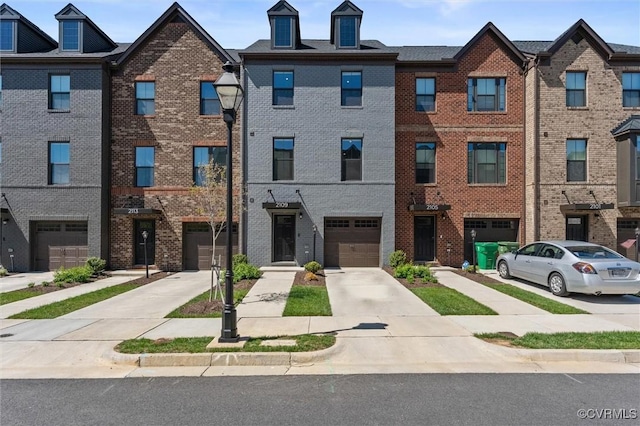 multi unit property featuring brick siding, an attached garage, and driveway