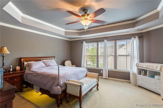 bedroom with a ceiling fan, light carpet, crown molding, and a tray ceiling
