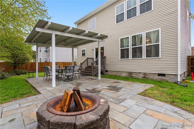 back of property featuring fence, a pergola, a yard, crawl space, and an outdoor fire pit