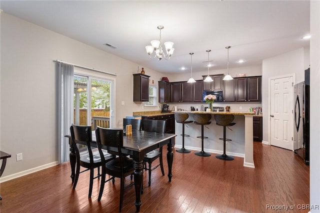 dining room with an inviting chandelier, baseboards, dark wood-type flooring, visible vents, and recessed lighting