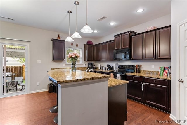 kitchen featuring dark wood finished floors, black appliances, dark brown cabinetry, and visible vents