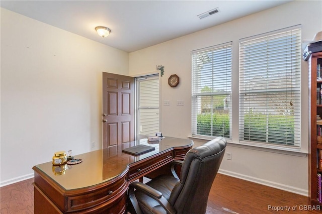 office space featuring wood finished floors, visible vents, and baseboards