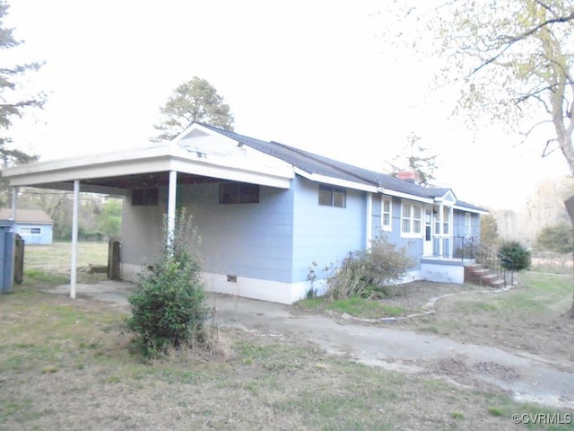 view of side of property with a carport and crawl space