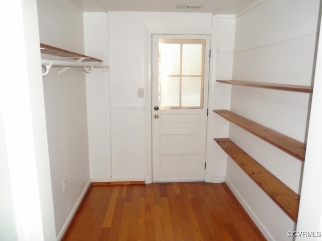 doorway to outside with wood finished floors, visible vents, and baseboards