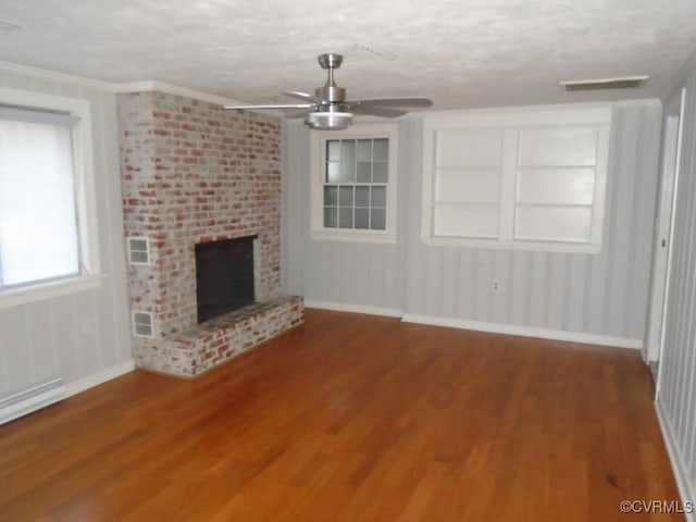 unfurnished living room featuring baseboards, a brick fireplace, wood finished floors, ceiling fan, and a baseboard radiator