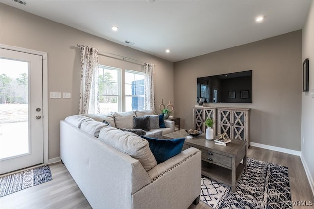 living area featuring baseboards, recessed lighting, wood finished floors, and visible vents