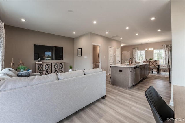 living room featuring an inviting chandelier, recessed lighting, and light wood-style flooring
