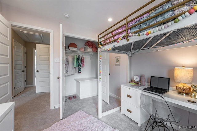 bedroom with a closet, attic access, baseboards, and light carpet