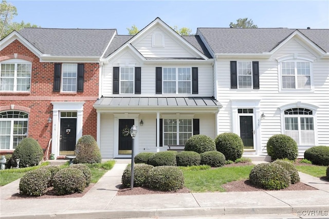 multi unit property featuring a standing seam roof and brick siding